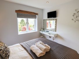 A bedroom with a bed and a mirror at Haystacks in Troutbeck