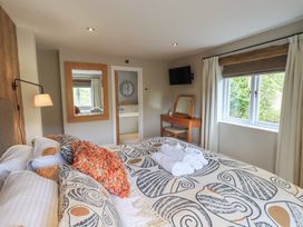 A bedroom with a bed and mirror at Haystacks in Troutbeck