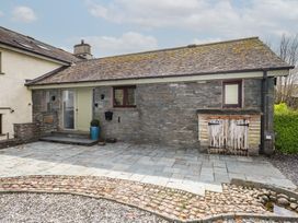 An outdoor view of a house with stone wall and patio at Haystacks in Troutbeck