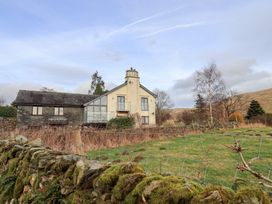 A house with a chimney and surrounding greenery at Haystacks in Troutbeck