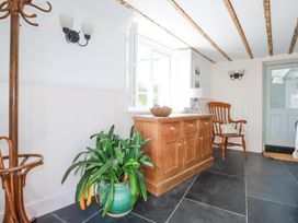 A room with a wooden cabinet plant a wooden chair and a coat rack at Hilldene in Treknow