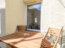 A wooden table with two wooden chairs on a small outdoor patio at Hilldene in Treknow