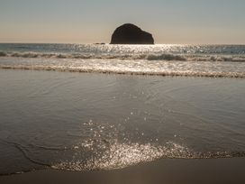 A view of a beach with waves and a rock formation at Hilldene in Treknow