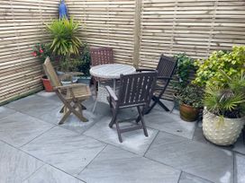 A garden area with a table and chairs surrounded by plants at Brixham Breeze Cabin in Brixham