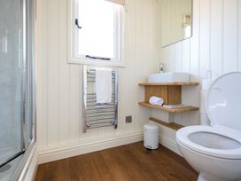 A bathroom with a toilet sink mirror towel rack and shower at Strathmore Burnside near Forfar