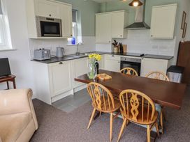 A kitchen with a table and chairs at Honeysuckle Cottage in Crookham near Cornhill-On-Tweed