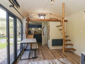 A kitchen and dining area with wooden stairs and loft at Longlands Lodge Longlands near Caldbeck