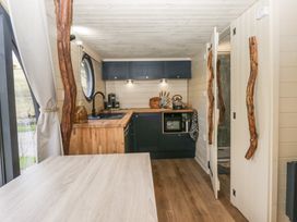 A kitchen with wooden countertops blue cabinets and round window at Longlands Lodge Longlands near Caldbeck