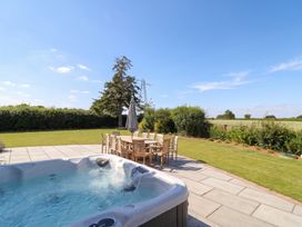 A garden with a hot tub and dining table at Daniels Farmhouse in Claines