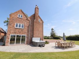 An outdoor area with a hot tub and dining set at Daniels Farmhouse in Claines