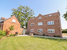 A garden with brick houses and trees at Daniels Farmhouse in Claines