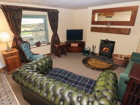 A living room with a sofa and fireplace at 2 Strand Cottages in Carmarthen