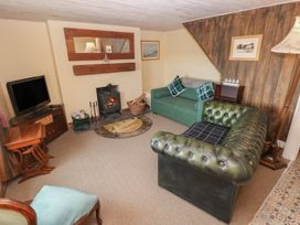 A living room with a fireplace and television at 2 Strand Cottages in Carmarthen