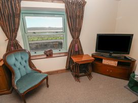 A living room with a window and a chair at 2 Strand Cottages in Carmarthen