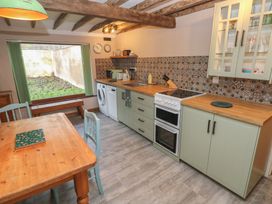 A kitchen with a wooden table and chairs at 2 Strand Cottages in Carmarthen
