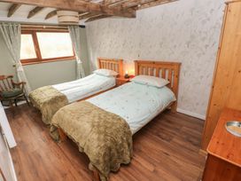 A bedroom with two twin beds and a dresser at 2 Strand Cottages in Carmarthen