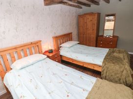 A bedroom with two single beds and furniture at 2 Strand Cottages in Carmarthen