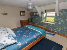 A bedroom with a bed and a chest of drawers at 2 Strand Cottages in Carmarthen
