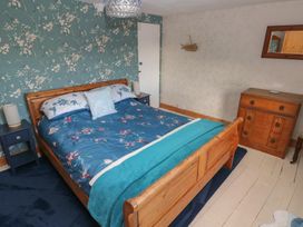 A bedroom with a bed and dressing table at 2 Strand Cottages in Carmarthen