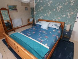 A bedroom with a bed and nightstand at 2 Strand Cottages in Carmarthen