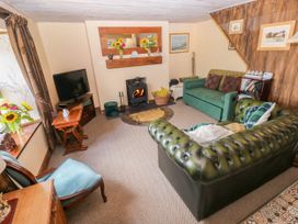 A living room with furniture and a fireplace at 2 Strand Cottages in Laugharne