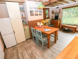 A kitchen with a dining table and chairs at 2 Strand Cottages in Laugharne