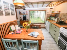 A kitchen with a table and chairs at 2 Strand Cottages, Laugharne