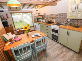 A kitchen with a table and chairs at 2 Strand Cottages in Laugharne