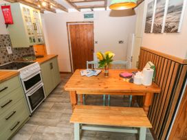 A kitchen with a dining table and chairs at 2 Strand Cottages in Laugharne