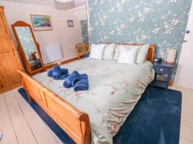 A bedroom with a bed and bedside table at 2 Strand Cottages in Laugharne