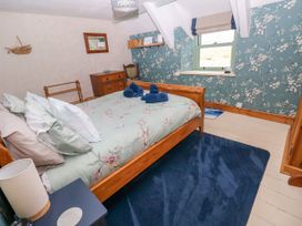A bedroom with a bed and bedside lamp at 2 Strand Cottages in Laugharne