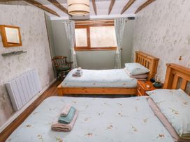 A bedroom with two beds and a window at 2 Strand Cottages in Laugharne