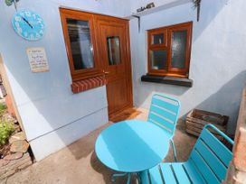 An outdoor area with a table and chairs at 2 Strand Cottages in Laugharne