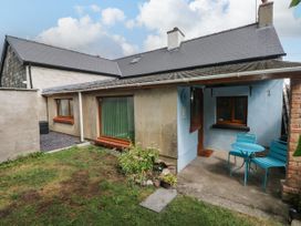 An outdoor view of a cottage with table and chairs at 2 Strand Cottages in Laugharne