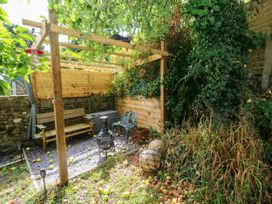 A garden with seating and greenery at 2 Strand Cottages in Laugharne