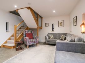 A living room with a staircase and seating at The Hay Barn in Huntley