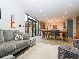 A living room with a sofa and dining area at The Hay Barn in Huntley