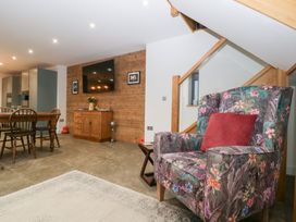 A living room with a chair and table at The Hay Barn in Huntley