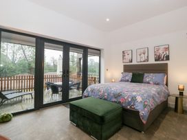 A bedroom with a bed and sliding doors at The Hay Barn in Huntley