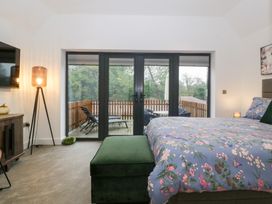 A bedroom with a bed and television at The Hay Barn in Huntley