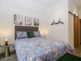 A bedroom with a bed and wall art at The Hay Barn in Huntley
