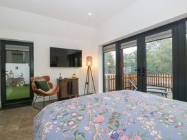 A bedroom with a bed and television at The Hay Barn in Huntley