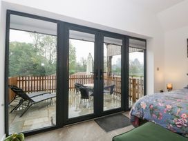 A bedroom with sliding glass doors leading to a deck at The Hay Barn in Huntley