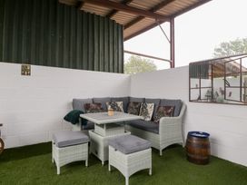 An outdoor seating area with a sofa and table at The Hay Barn in Huntley