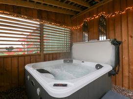 A hot tub in a wooden structure with lights at The Hay Barn in Huntley