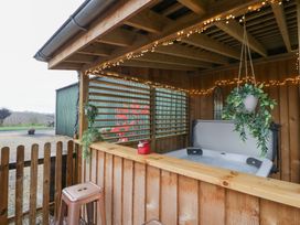 An outdoor area with a hot tub and wooden fence at The Hay Barn Huntley