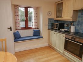 A kitchen with a window and bench seating at Bridge Cottage in Budleigh Salterton