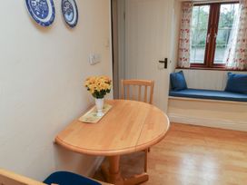 A dining room with a table and chairs at Bridge Cottage in Budleigh Salterton