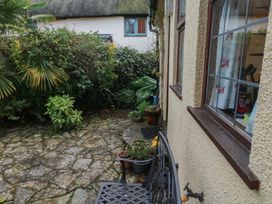 A garden with plants and a stone patio at Bridge Cottage in Budleigh Salterton