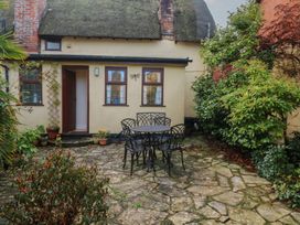 A garden with a table and chairs at Bridge Cottage in Budleigh Salterton
